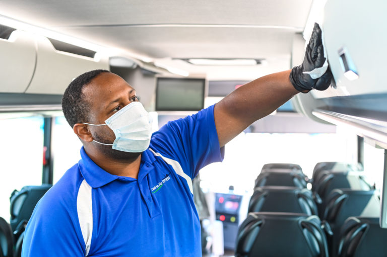 Man in Protective Gloves Cleaning Bus